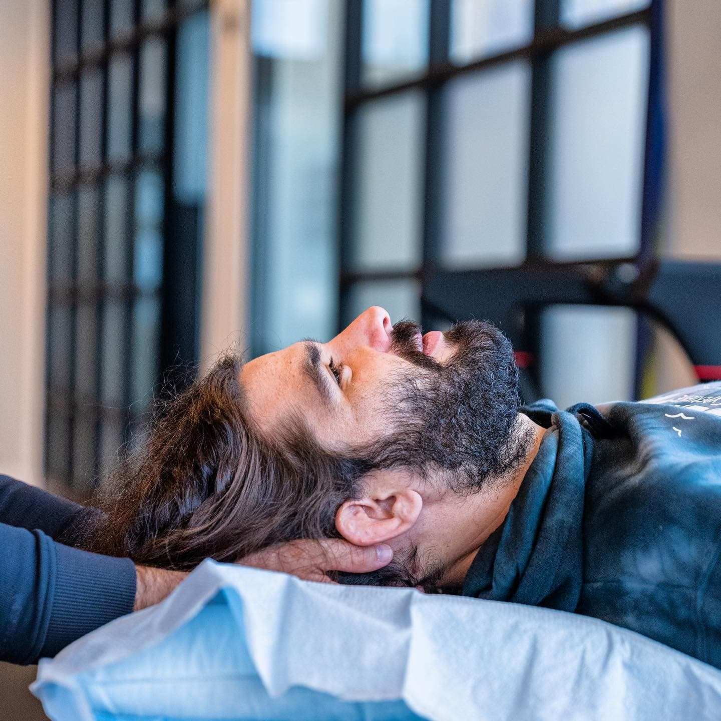 Man receiving neck support from a Chiropractor, in a modern clinic setting
