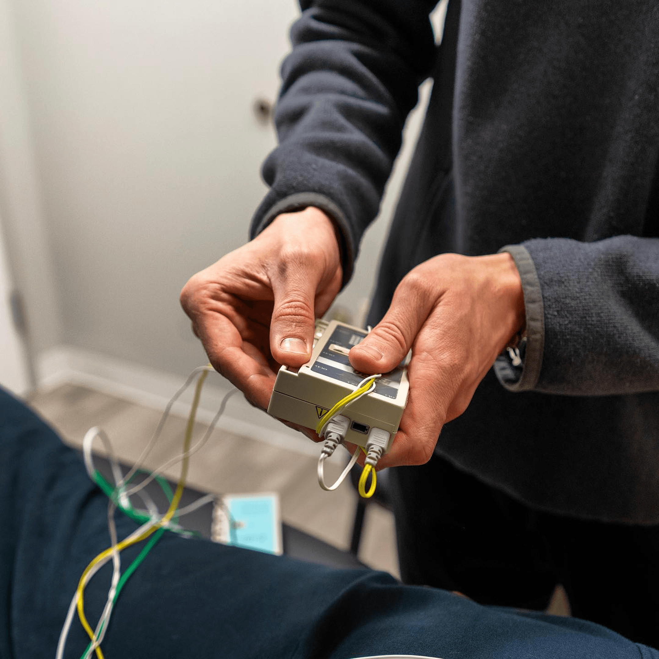 Acupuncturist adjusting an electro-acupuncture stimulator connected to a patient's needles at Thrive Freehold