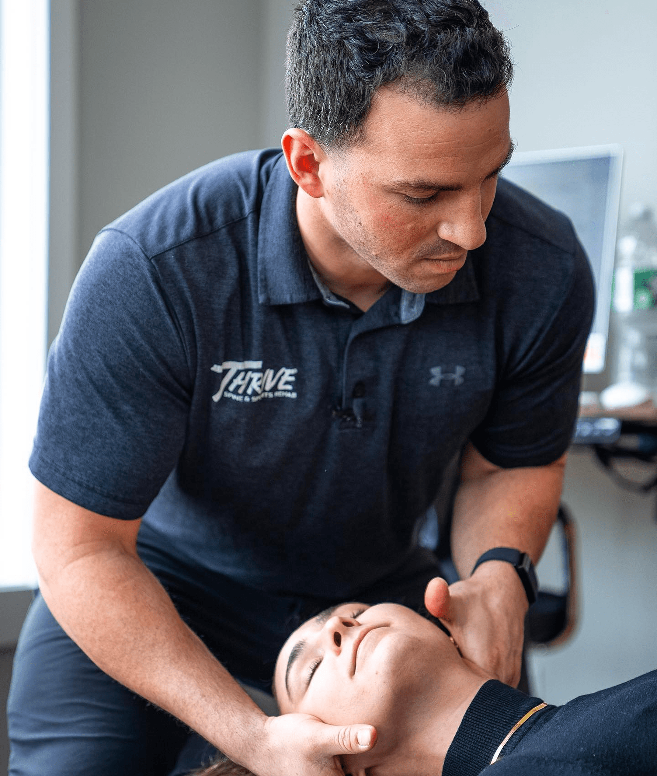 Dr. Vinny Zappola treating a patient's neck at Thrive Freehold